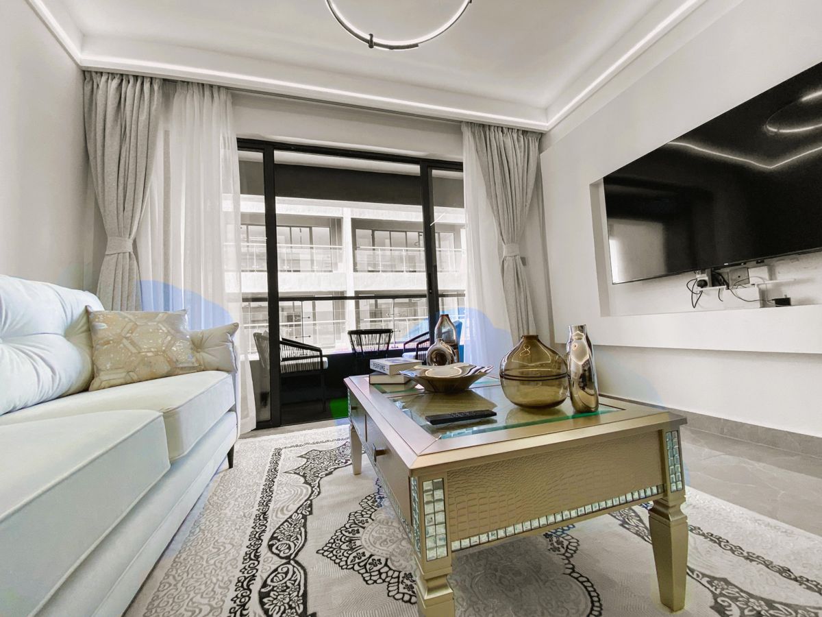 Bright living room with a white sofa, gold coffee table and balcony