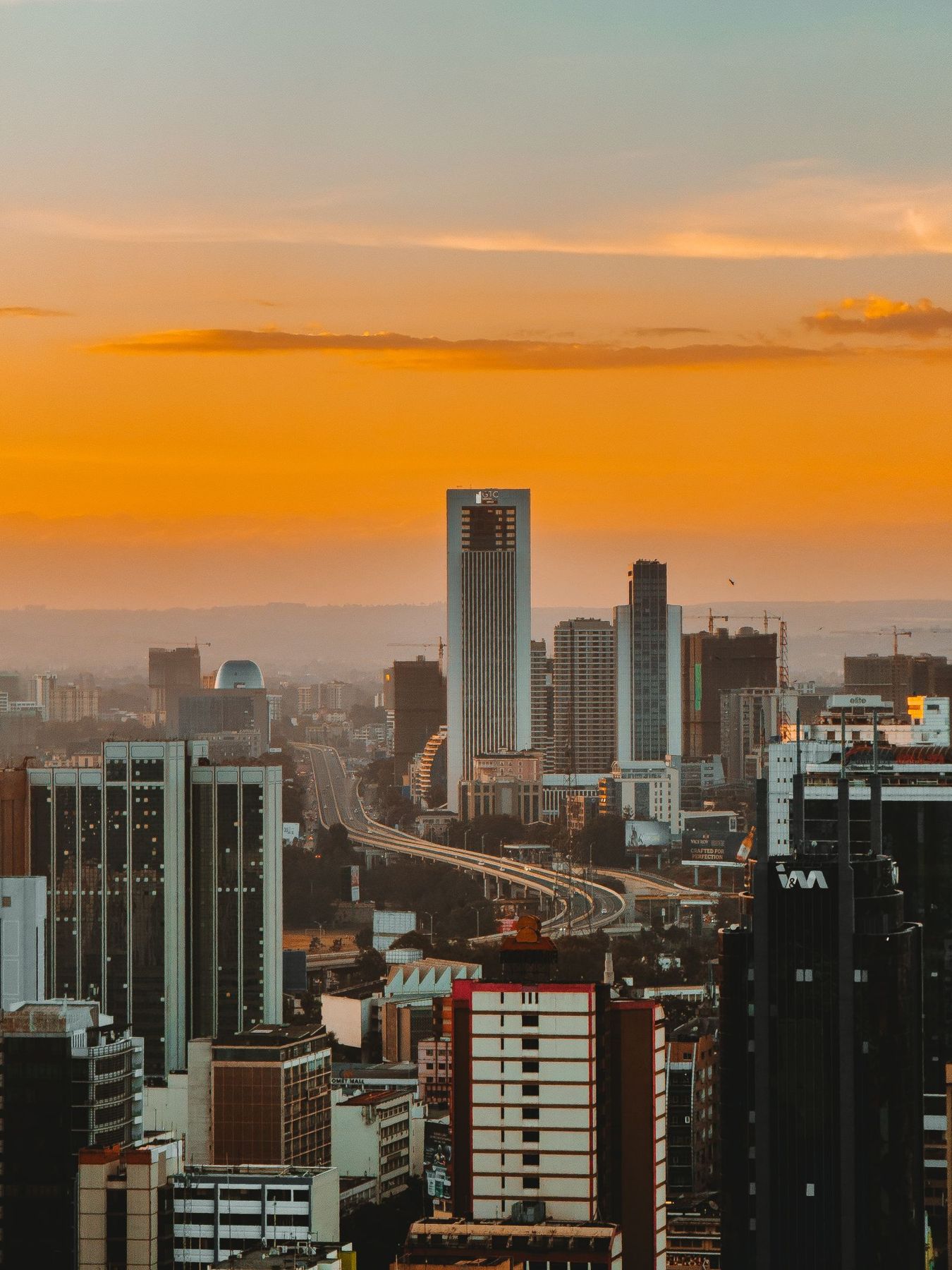 Nairobi city skyline under an orange sunset sky
